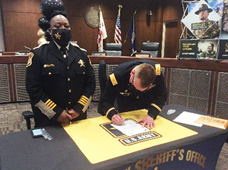 LTC Erik Peterson, Commander, Richmond Recruiting Battalion and Sheriff Karen Bowden, Hampton Sheriff`s Office both take turns signing the Army PaYS Ceremonial Agreement
