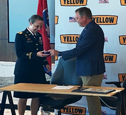 Yellow Corporation CEO Darren Hawkins presents LTC Kirsten McFarland with the company's military challenge coin.
