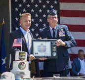 Mr. Trey Mytty, CEO, Truck Center Companies and MG Daryl Bohac, Adjutant General, Nebraska National Guard, sign the Ceremonial Agreement Form and pose with the PaYS Certificate of Participation Plaque.