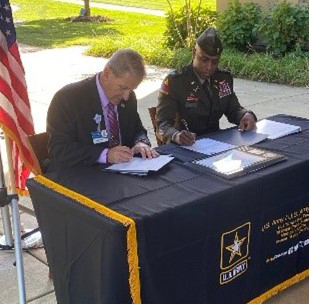 Phil Kambic, CEO, Riverside Healthcare and LTC Shane Doolan, Commander, Chicago Recruiting Battalion sign the PaYS Ceremonial Agreement during the signing ceremony in Kankakee, IL 