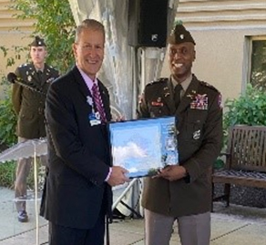 LTC Shane Doolan presents the PaYS Certificate of Participation Plaque to Riverside Healthcare CEO Phil Kambic.