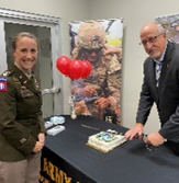(l-r) LTC McFarland and Mr. Davis cut the cake using a ceremonial Army Saber