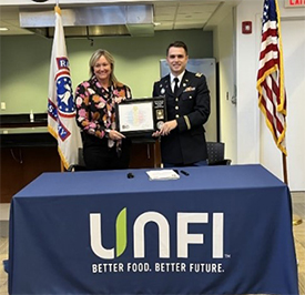 (l-r) Ms. Benedicts and CPT Waldron presenting the Ceremonial Plaque (l-r) Ms. Benedicts and CPT Waldron presenting the Ceremonial Plaque