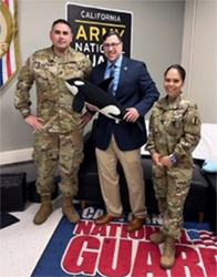 (l-r) First Sergeant Gastelum, Mr. Carter, and Master Sergeant Pavur pose with the company mascot, Killer Whales.benefits of the PaYS program.