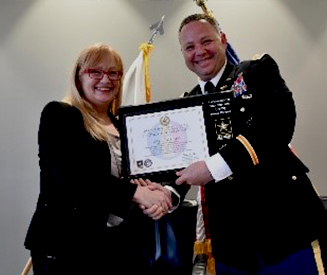 LTC Harrel presents the ceremonial PaYS Plaque to Mrs. Damerow, a symbol of the finalized partnership.