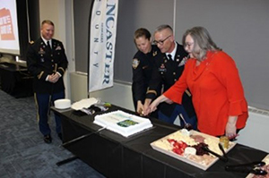 (l-r) MAJ Sean O’Neill, Executive Officer Nebraska Army National Guard Recruiting and Retention Battalion, supervises as Chief Ewins, COL Wescamp and Commissioner Yoakum cut the cake.