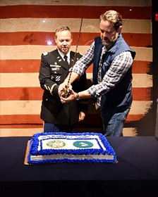 (l-r) LTC Harrell and Mr. Sweigart cut the cake at the reception following the signing ceremony.