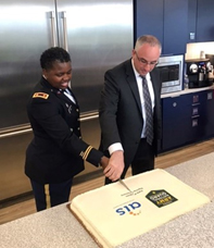 MAJ Wynn and Mr. Katzman, cut the cake signifying their partnership.