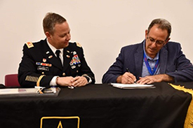(l-r) LTC Harrell and Mr. Showah sign the ceremonial agreement.