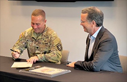 (l-r) LTC Brian Meister signs the ceremonial agreement, as Rob Taylor looks upon with pride.