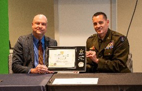 BG Erickson of the NDARNG presents Mr. Wilson the PaYS Ceremonial Plaque for Trinity Health.