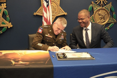 LTG Stitt and Mr. Smith sign the ceremonial agreement. LTG Stitt and Mr. Smith sign the ceremonial agreement.
