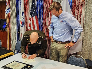 (l-r) LTC Horvath and Mr. Vandergriend sign the Ceremonial PaYS Memorandum of Agreement. (l-r) LTC Horvath and Mr. Vandergriend sign the Ceremonial PaYS Memorandum of Agreement.RRB present plaque to Tom Frank, CEO & President Radius Packaging