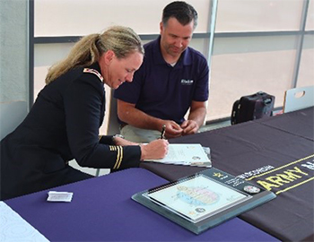 LTC Shannon Hellenbrand signs the ceremonial partnership agreement.