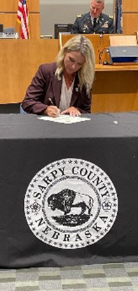 Mrs. Burmeister signs the Sarpy County ceremonial MOA. Mrs. Burmeister signs the Sarpy County ceremonial MOA.