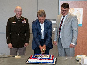 Governor Jim Pillen, Mr. Hilgert, and BG Heng cut the cake following the ceremony.