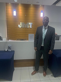 Dejoel Whitaker poses in front of JMT branding. Dejoel Whitaker poses in front of JMT branding.