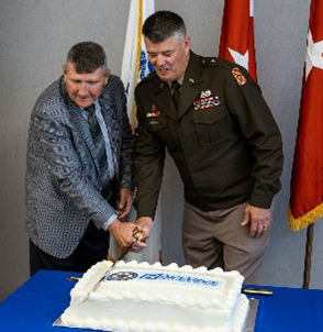 BG Terry Grisham and Bill Bailey cutting the cake with a saber.