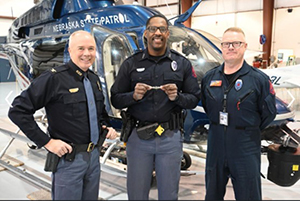 Trooper Moore is presented his wings as the newest pilot in the NSP Aviation Support Division