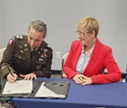 LTC McFarland signs the TurnPoint Service ceremonial MOA with Ms. Buccelli.