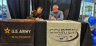 LTC Cox signs the Courtesy Auto Group ceremonial MOA, Mr. Grace awaits his turn to sign.