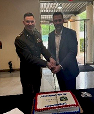 MAJ Springer and Mr. Nemecek participate in a ceremonial cake cutting.