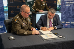 Mr. Bowen signs the MOA as LTC McCart looks on