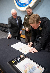 Director Kelly signs ceremonial MOA as LTC Collins and CASA Moulton look on. Director Kelly signs ceremonial MOA as LTC Collins and CASA Moulton look on.